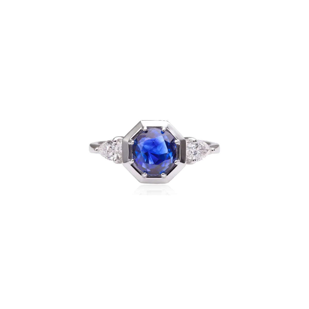 Blue sapphire trilogy ring with octagonal bezel and small diamond-like side stones